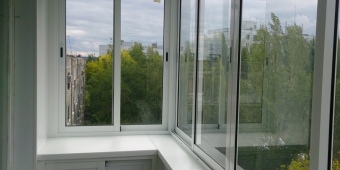 Холодное остекление Г - образного балкона с внутренней обшивкой пластиковыми панелями, встроенный шкаф